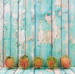 Fototapeta premium Sweet, exotic and delicious rambutan fruit over wooden background