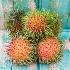 Sweet, exotic and delicious rambutan fruit over wooden background