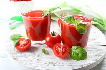 Glasses of fresh tomato juice on wooden table, closeup