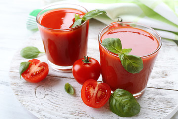 Glasses of fresh tomato juice on wooden table, closeup