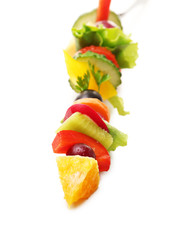 Snack of vegetables on fork isolated on white