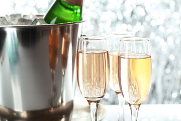 Glasses of champagne on bright background