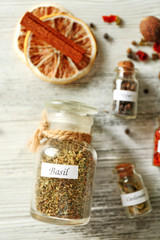 Assortment of spices in glass bottles on wooden background