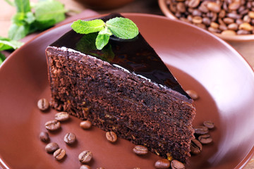 Delicious chocolate cake with mint on plate on table close up