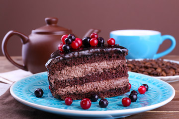 Delicious chocolate cake with berries on plate on table close up