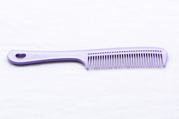 Purple hair comb on white background
