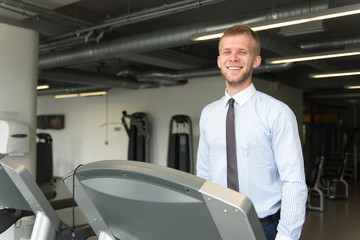 Fototapeta na wymiar Businessman Running On Treadmill In Gym