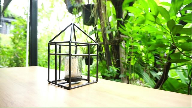 Candle holder in black metal frame with nature background