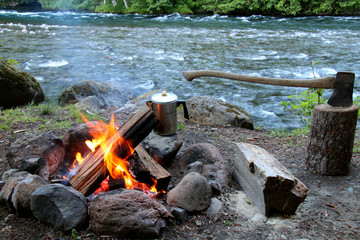 campfire with axe wood river and coffee pot