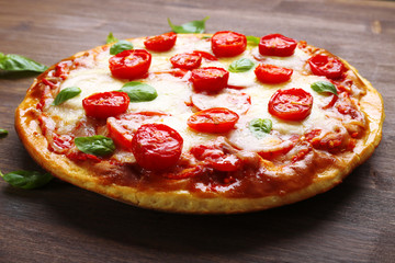 Delicious pizza with cheese and cherry tomatoes on wooden table, closeup