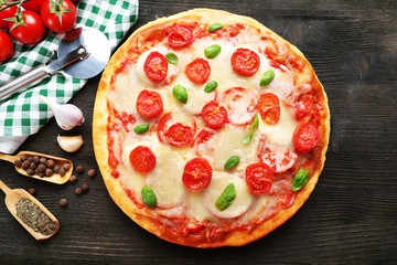 Delicious pizza with cheese and cherry tomatoes on wooden table, top view
