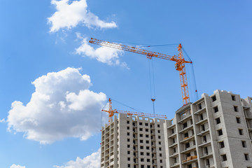 Tall cranes on a blue sky background