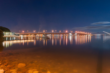 Fototapeta premium Tauranga night scene bridge lights and city lights across bay under new moon