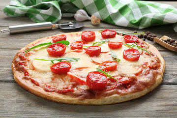 Delicious pizza with cheese and cherry tomatoes on wooden table, closeup
