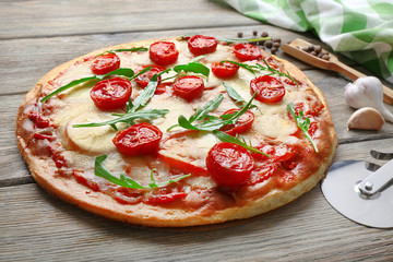 Delicious pizza with cheese and cherry tomatoes on wooden table, closeup