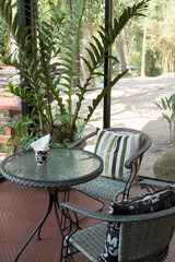 Two rattan cafe chairs on the brown ground