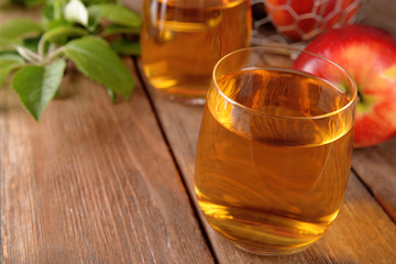 Glasses of apple juice on wooden table, closeup