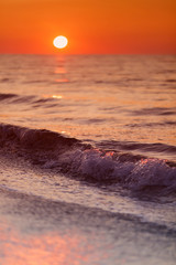Obrazy na Szkle  Beautiful waves on sunset over beach