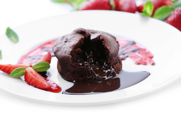 Chocolate fondant with strawberries on white plate, closeup
