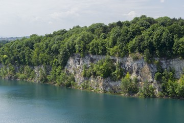 Limestone quarry lake with deep blue water and steep walls