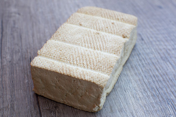 Delicious smoked tofu on wood table from side
