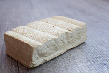 Delicious smoked tofu on wood table from side