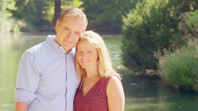 Mature Couple Smile near a Pond in a Park