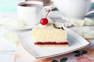 Tasty piece of cheesecake on plate on table close up