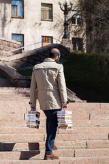 Fototapeta na wymiar Man holding a stack of books