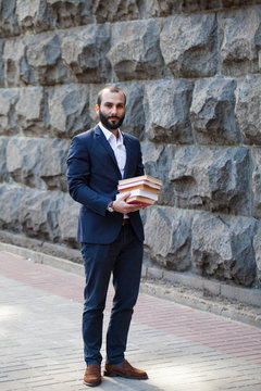 Young man holding many books