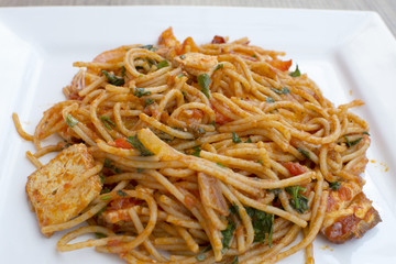 Vegan spaghetti with tofu and pepper delicious on white plate