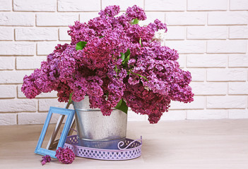 Beautiful lilac flowers in pail on floor in room close-up
