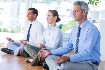 Business people doing yoga on floor 