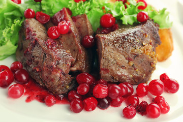 Tasty roasted meat with cranberry sauce on plate, close-up