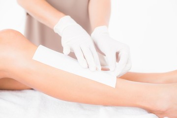 Obraz na płótnie Canvas Therapist waxing womans leg at spa center