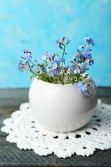 Composition with Forget-me-nots flowers on wooden background