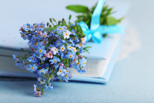 Forget-me-nots flowers on book, on blue background