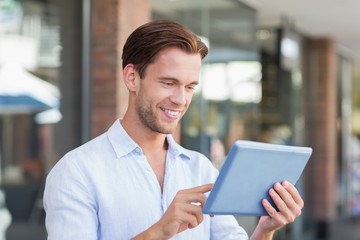 A happy smiling man using his tablet 