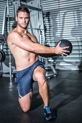 Fototapeta na wymiar Portrait of muscular man doing exercise with medicine ball