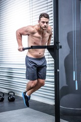 Obraz na płótnie Canvas Portrait of muscular man exercising with bars