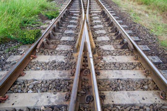 railroad tracks with railroad switch, two paths come together