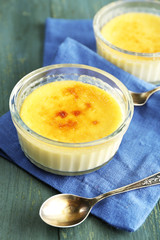 Creme brulee dessert  on napkin, on color wooden background
