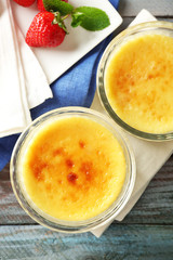 Creme brulee dessert  on napkin, on color wooden background