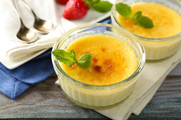 Creme brulee dessert  on napkin, on color wooden background