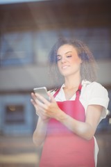 Smiling waitress sending a text