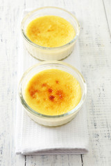 Creme brulee dessert  on napkin, on color wooden background