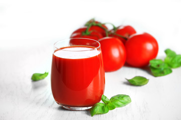 Tomato juice and fresh tomatoes on wooden table close-up
