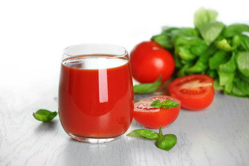 Tomato juice and fresh tomatoes on wooden table close-up