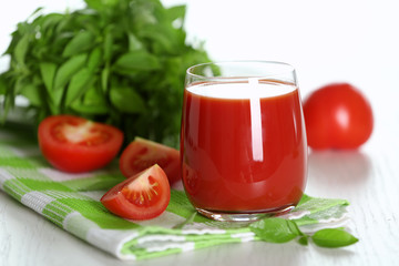 Tomato juice and fresh tomatoes on wooden table close-up