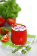 Tomato juice and fresh tomatoes on wooden table close-up